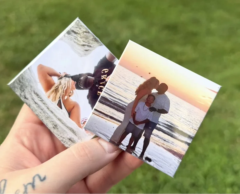 Two personalized rectangular photo magnets held in one hand