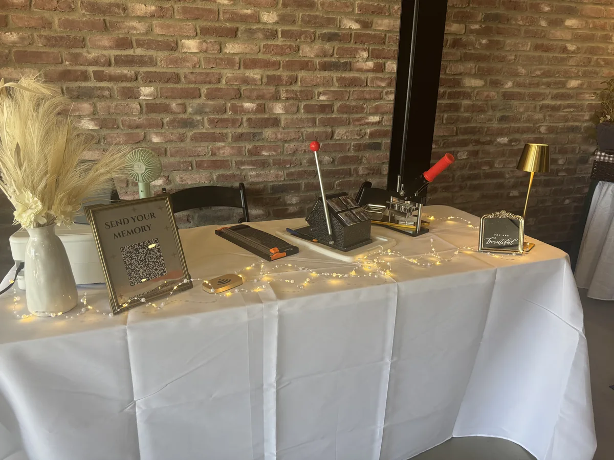 Keepsake vendor table with floral accents in a warm brick-walled venue